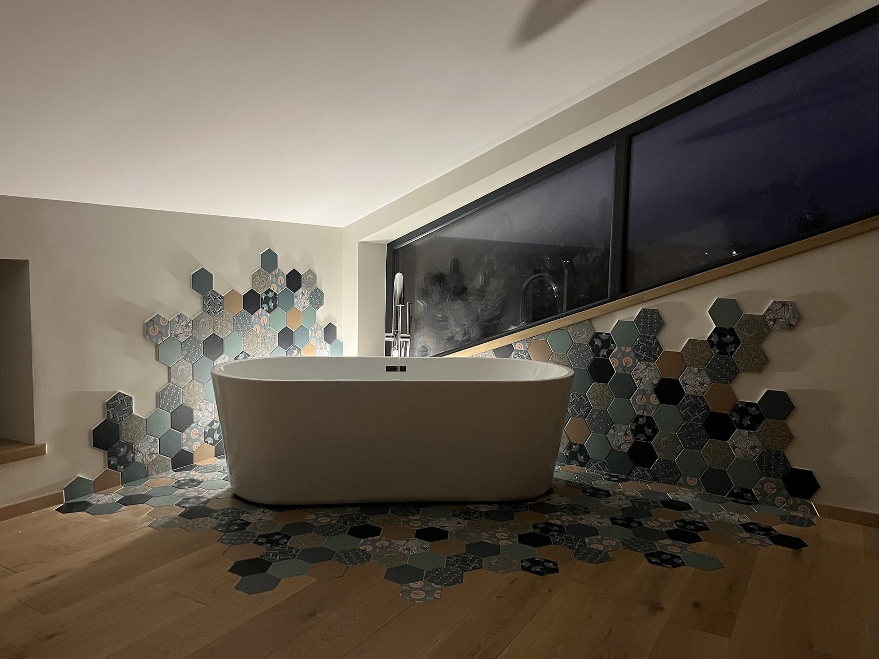 Salle de bains avec baignoire îlot et carreaux hexagonaux