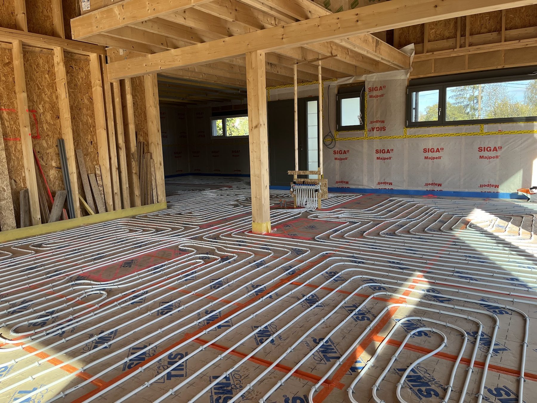 Tubes de plancher chauffant posés dans une maison à ossature bois